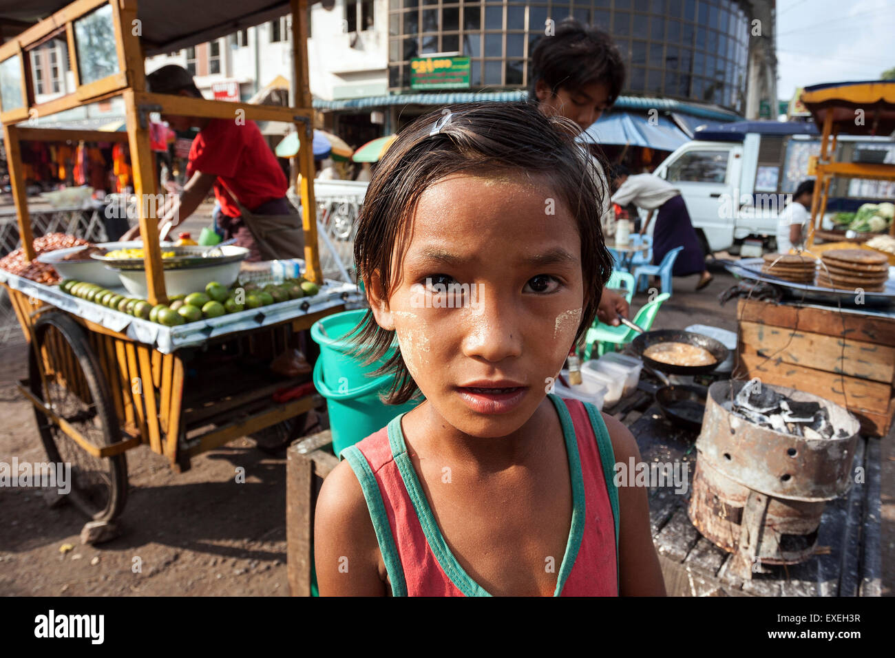 Local girl in front of food stalls, Gyar Tawya Street, Yangon, Myanmar Stock Photo