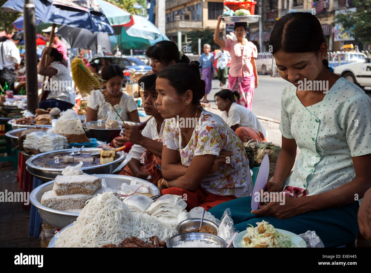 Women selling food at a roadside stall, Yangon, Myanmar Stock Photo