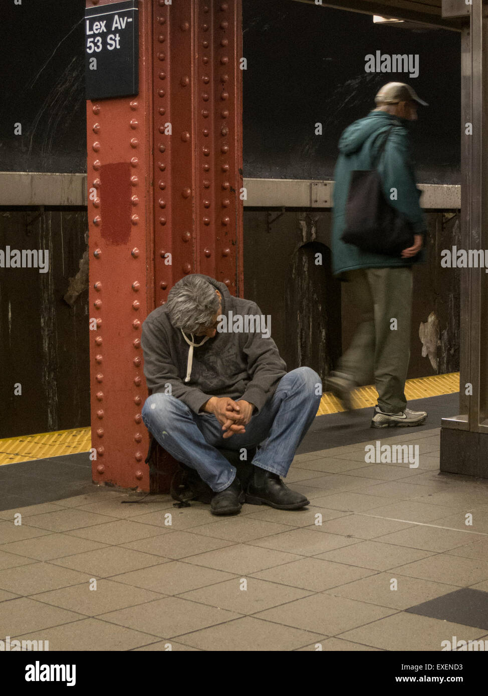 Sleeping man on the platform at an up-town subway station in New York Stock Photo