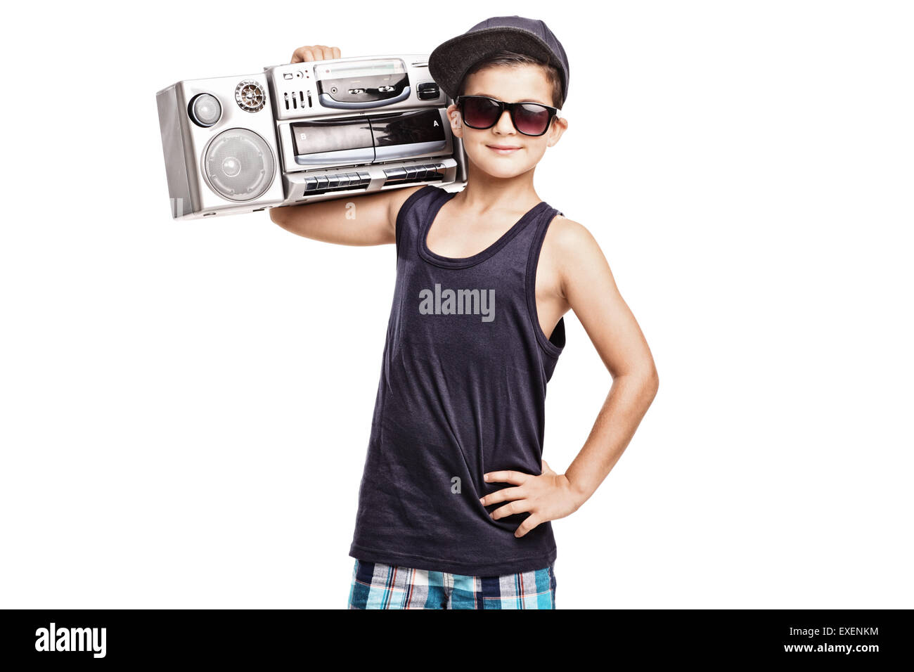 Cool boy in hip hop outfit holding a ghetto blaster over his shoulder and looking at the camera isolated on white background Stock Photo