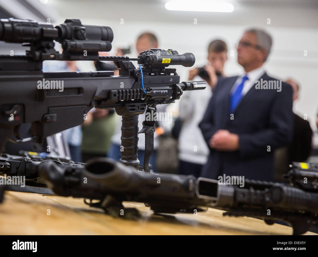 Mainz-Hechtsheim, Germany. 13th July, 2015. A machine gun and an automatic pistol lay on a table at a special presentation at a press conference in Mainz-Hechtsheim, Germany, 13 July 2015. The State Inner Minister for Rheinland-Palantine Roger Lewentz (SPD, r) presented earlier some consequences of a possible terrorist attacks with the heads of the SEK and the MEK (Mobiles Einsatz Kommando) forces. Issues such a as changes in the equipment, the functions and organization of the special forces have also been addressed. Photo:FRANK RUMPENHORST/dpa/Alamy Live News Stock Photo