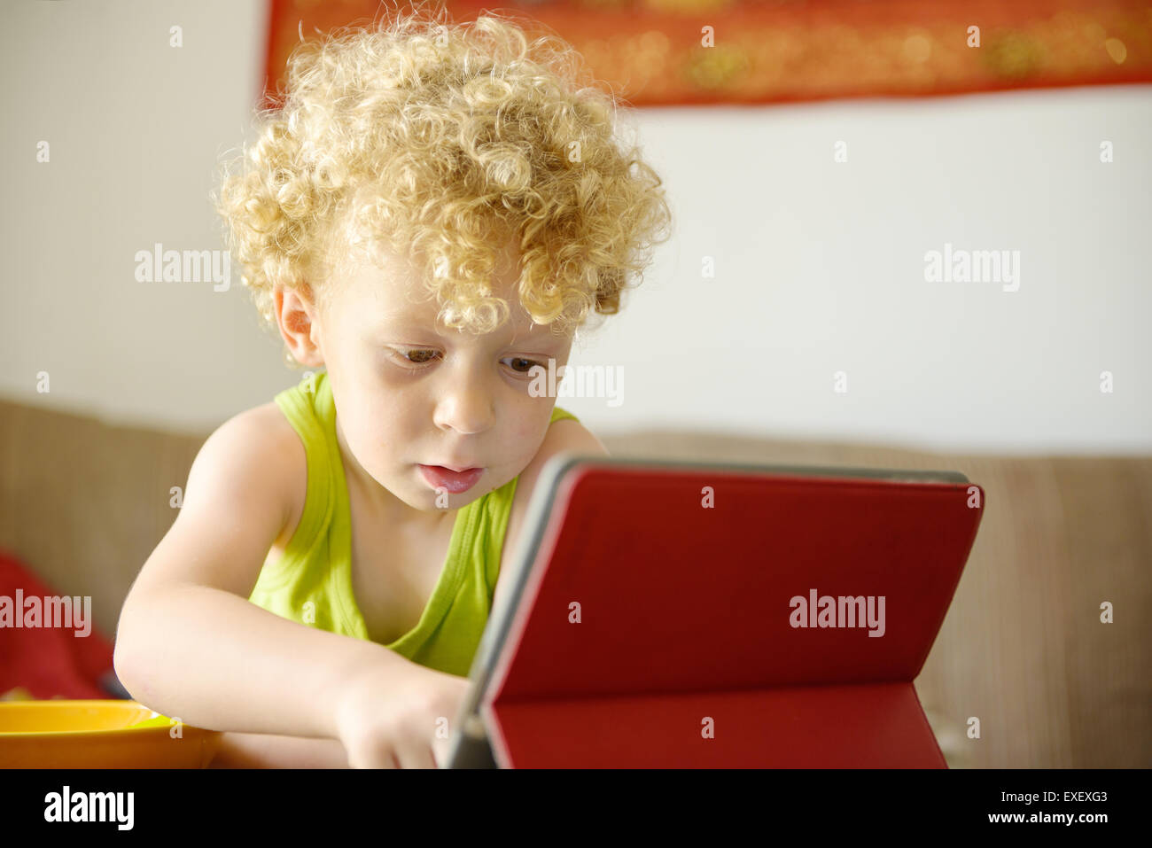 a little blond child looking at a digital tablet Stock Photo - Alamy