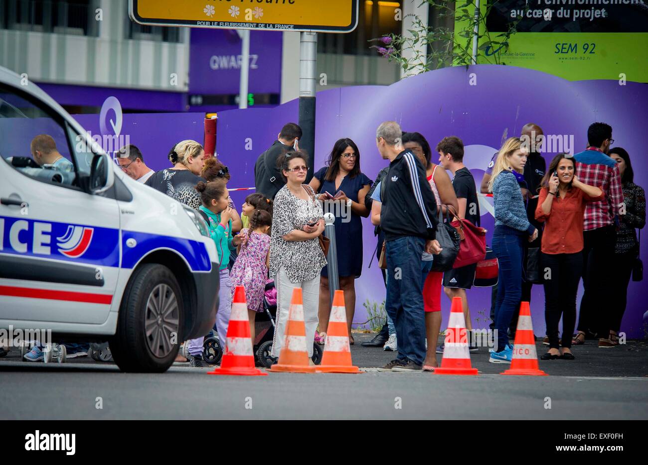 Paris, France. 13th July, 2015. People gather outside the site of a hostage helding in Paris, France, July 13, 2015. About 18 people have been evacuated from the shopping center where gunmen held employees hostage Monday morning in Villeneuve-la-Garenne, west Paris, police said. Credit:  Chen Xiaowei/Xinhua/Alamy Live News Stock Photo