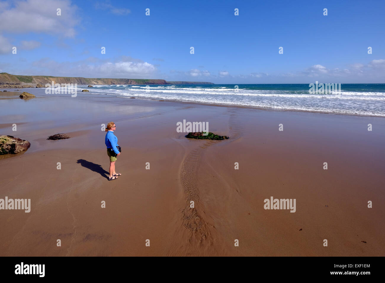 Female walker on Marloes Sands on the Pembrokeshire Coast, Wales UK Stock Photo