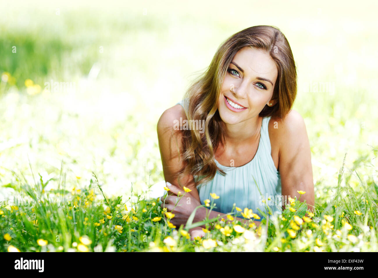 young woman in blue dress lying on grass Stock Photo - Alamy