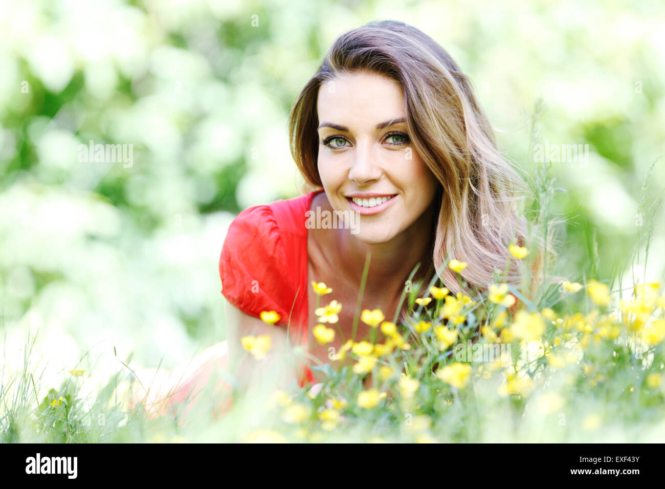 young woman in red dress lying on grass Stock Photo - Alamy