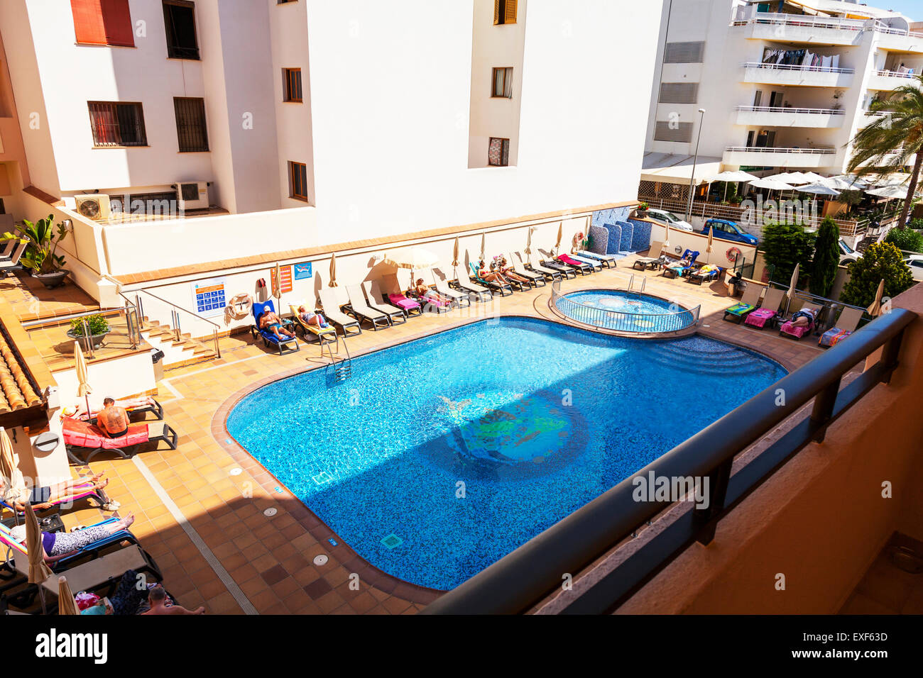 Hotel swimming pool outside Ibiza island Spain holiday sunbathers sunbathing sun Stock Photo