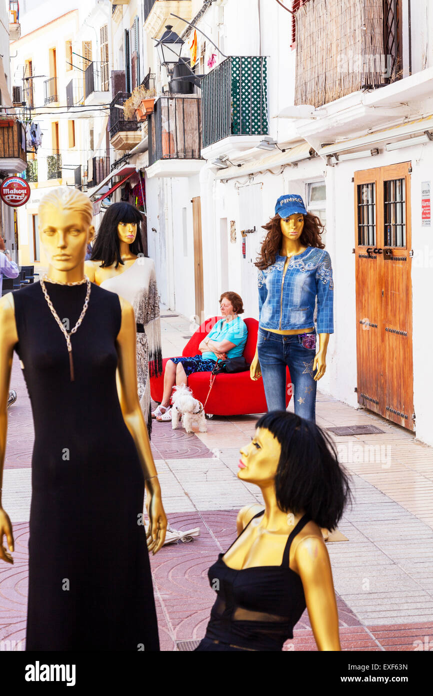 Female mannequins outside a store in Ibiza Old Town real woman sat on bench in background Stock Photo
