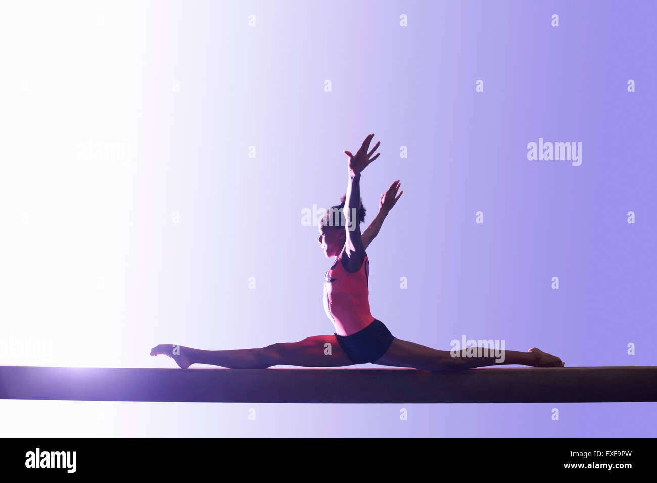 Young gymnast performing on balance beam Stock Photo