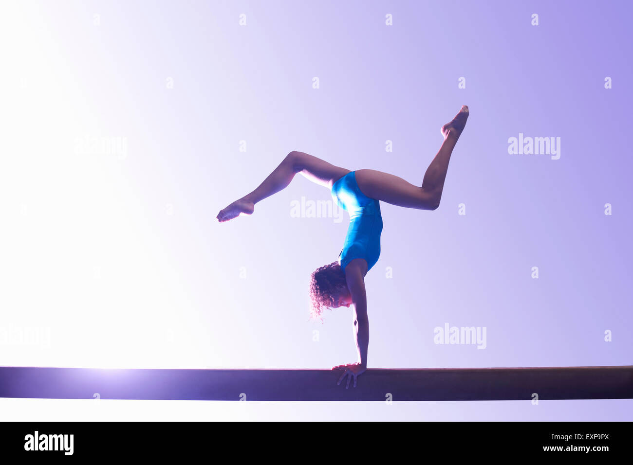 Young gymnast performing on balance beam Stock Photo