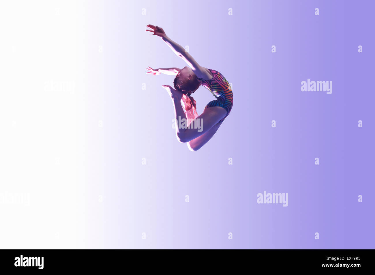 Young gymnast in mid-air leap Stock Photo