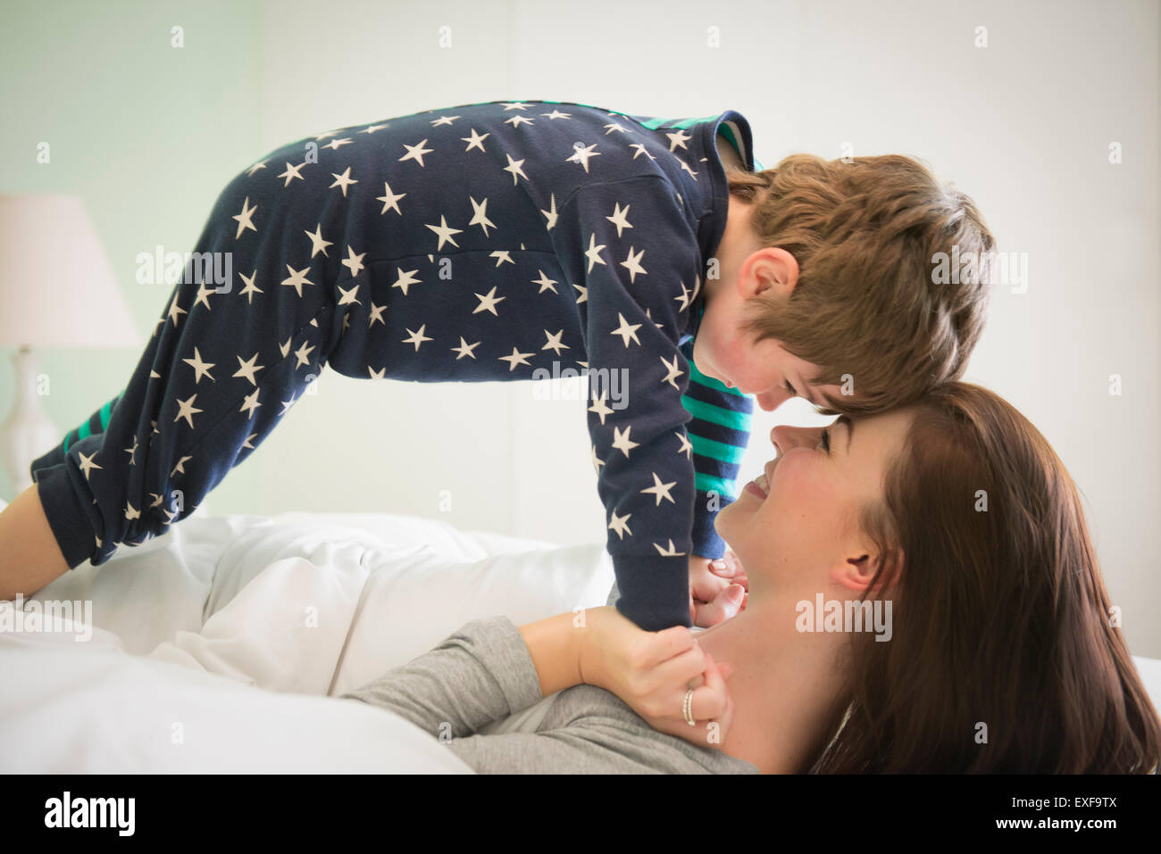 Mother and son playing together in bed Stock Photo
