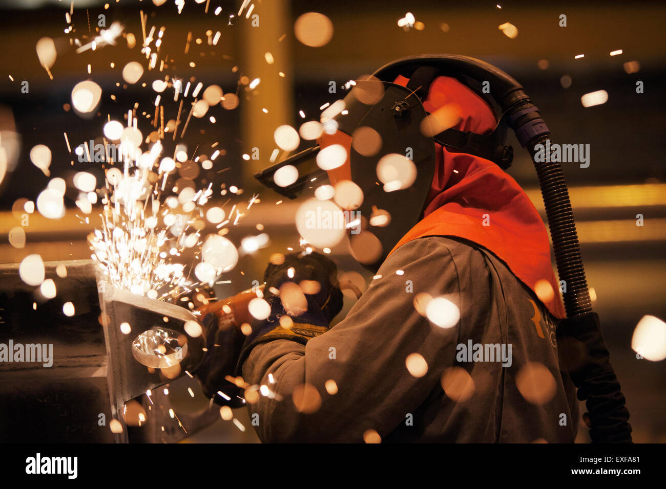 Sparks and worker using grinder Stock Photo
