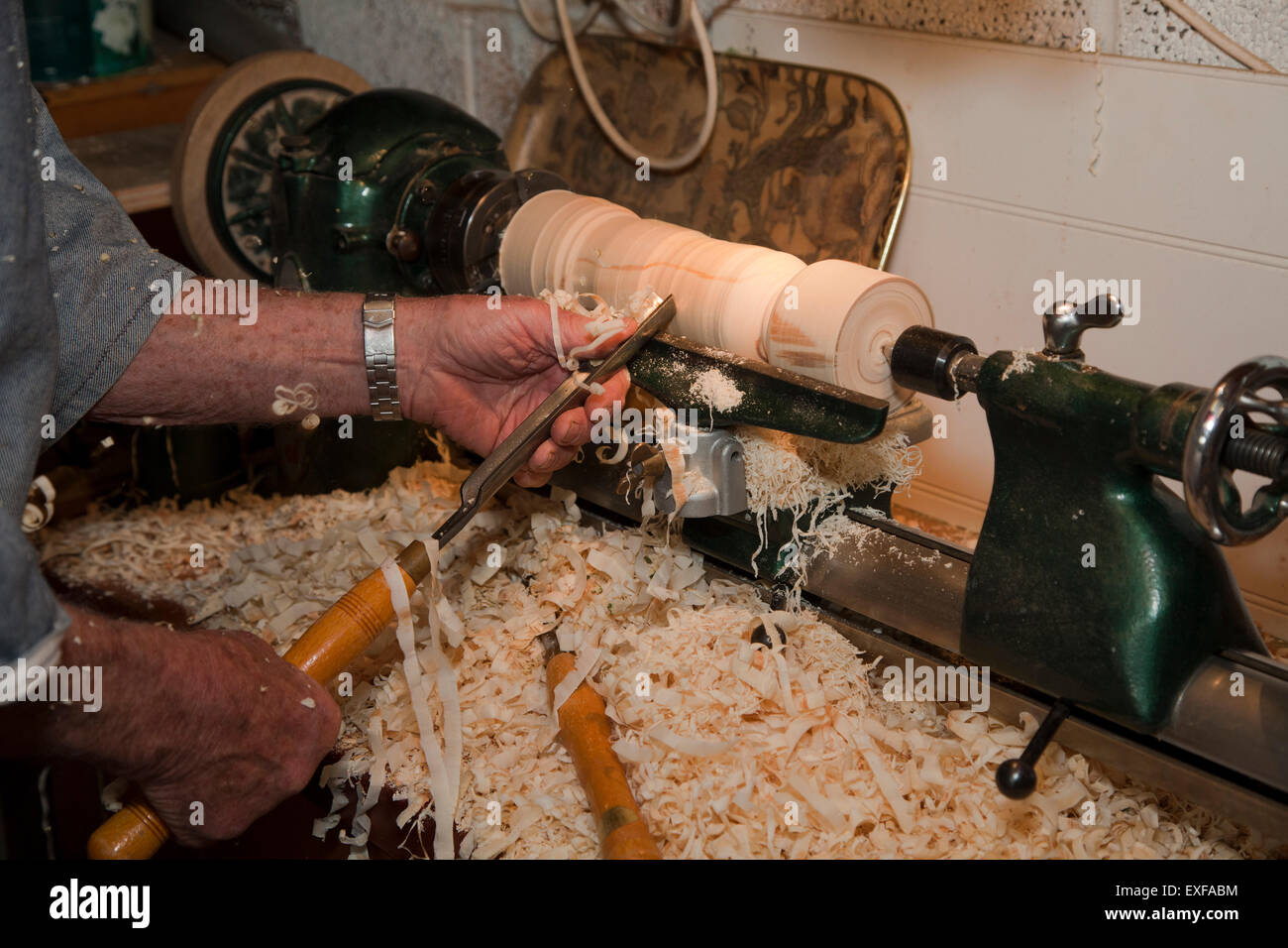 Senior man shaping piece of wood with carpentry tools, focus on hands Stock Photo