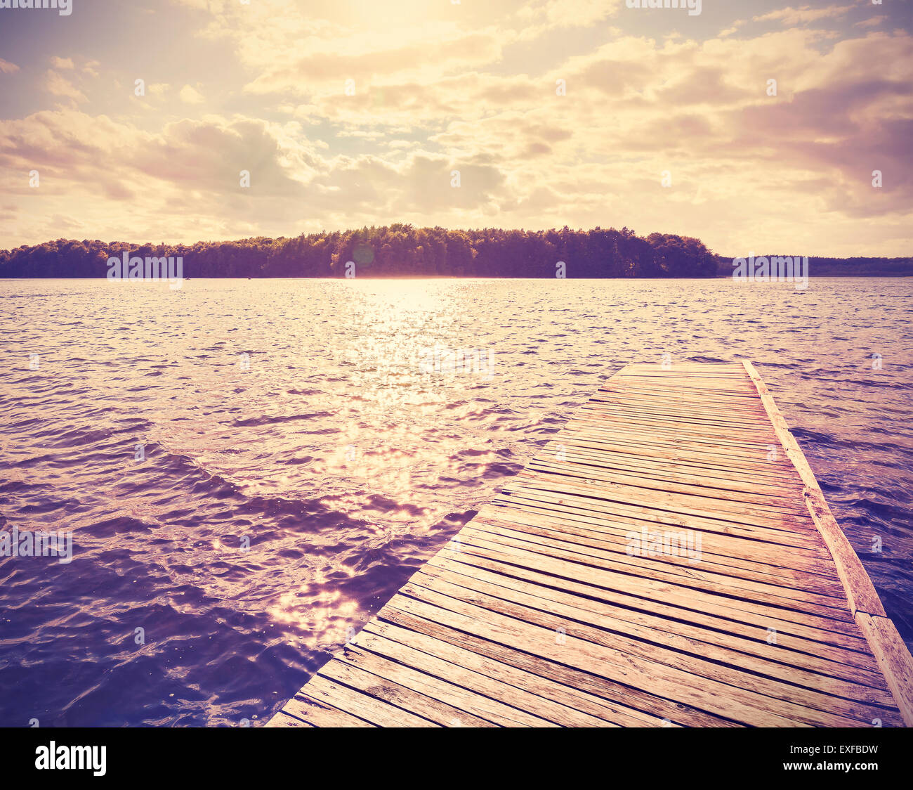 Vintage instagram filtered wooden pier at sunset. Stock Photo