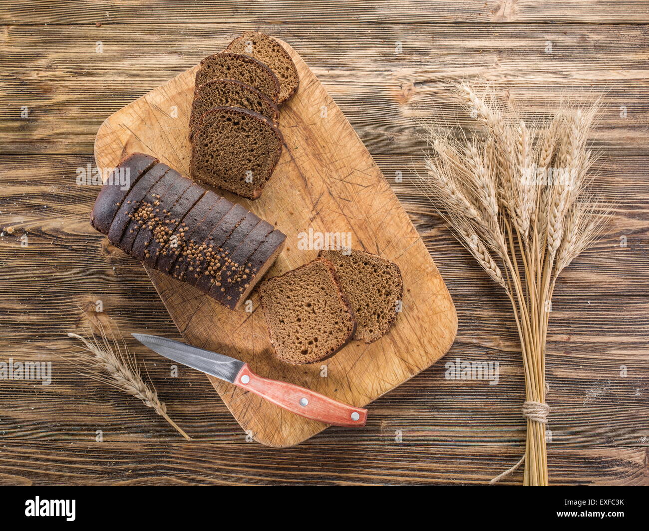 Sliced black bread on the old wooden plank. Stock Photo