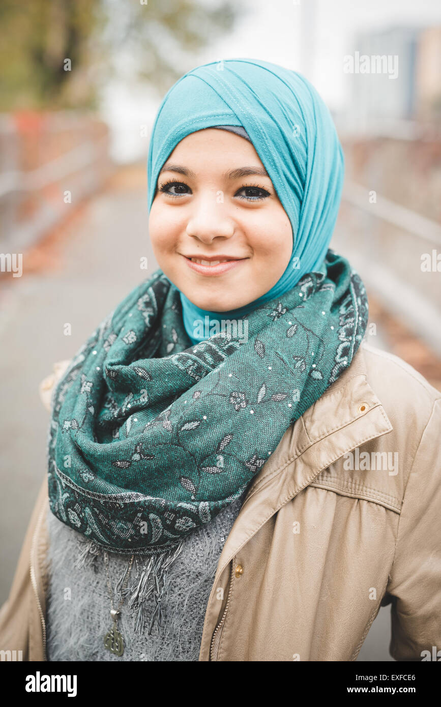 Portrait of young woman wearing turquoise hijab on park path Stock Photo