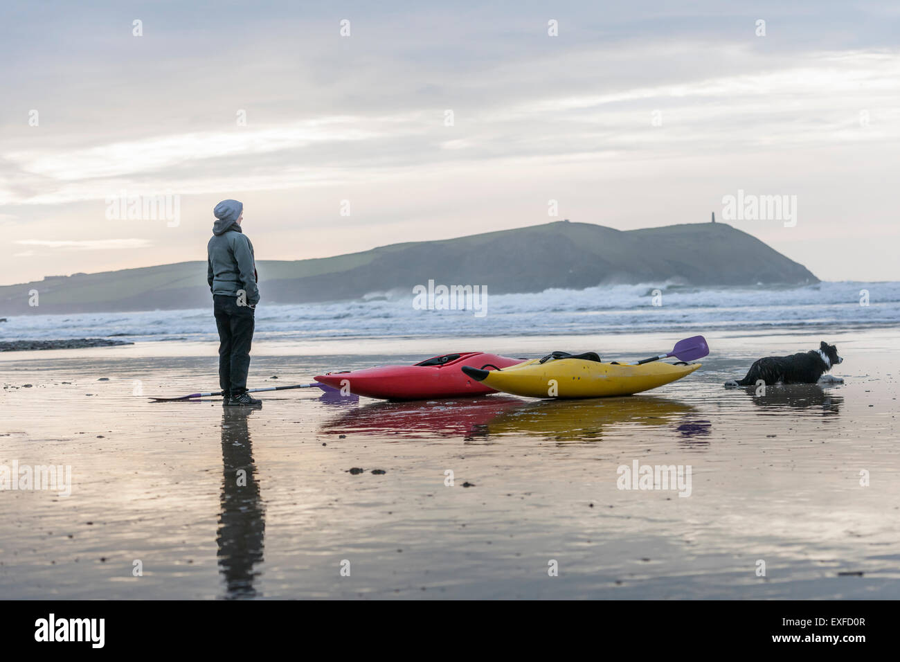 Young woman on beach with sea kayaks, Polzeath, Cornwall, England Stock Photo Alamy