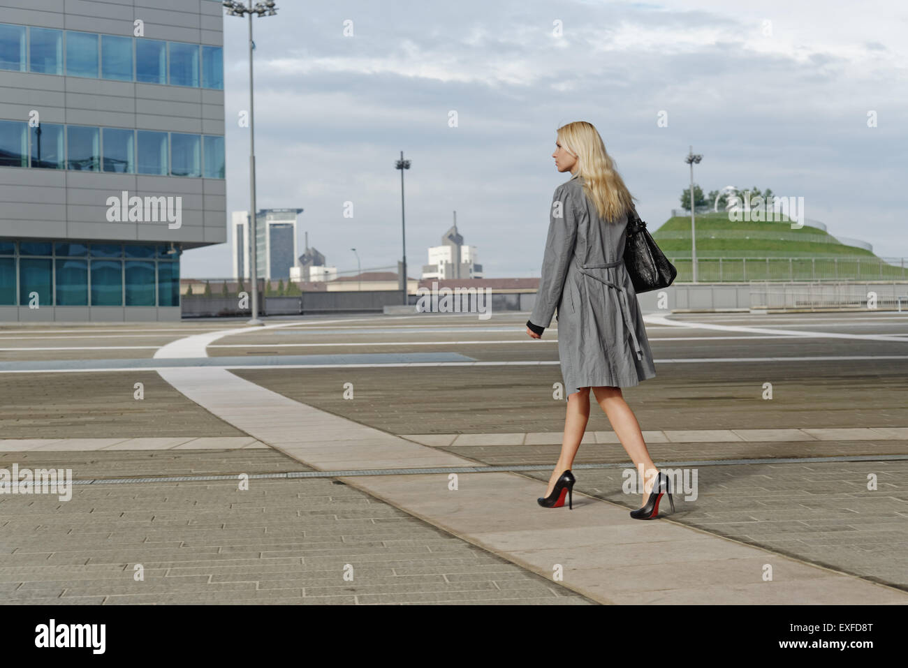 Businesswoman, walking outdoors along pathway, rear view Stock Photo