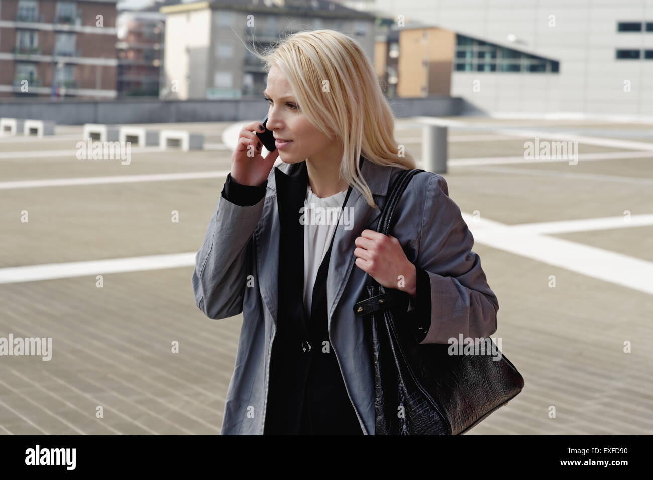 Businesswoman, walking outdoors, using mobile phone Stock Photo