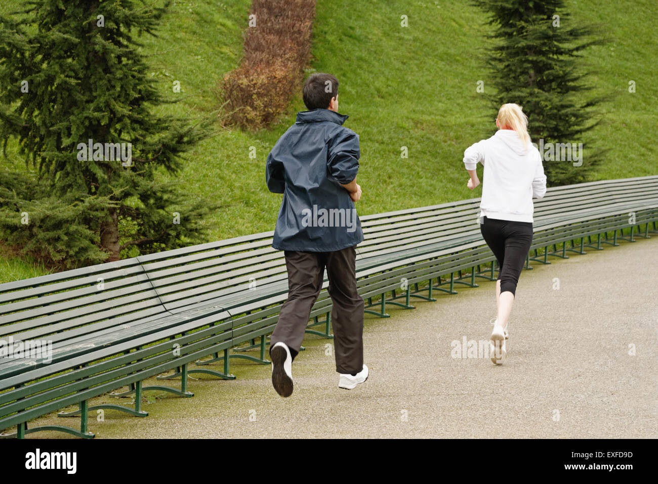 Man and woman running along pathway, rear view Stock Photo