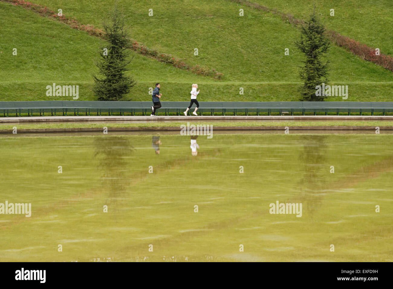 Man and woman running beside lake Stock Photo