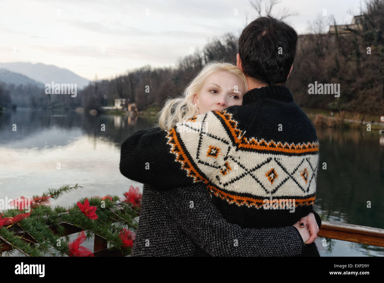 Heterosexual couple embracing beside lake, Lombardy, Italy Stock Photo
