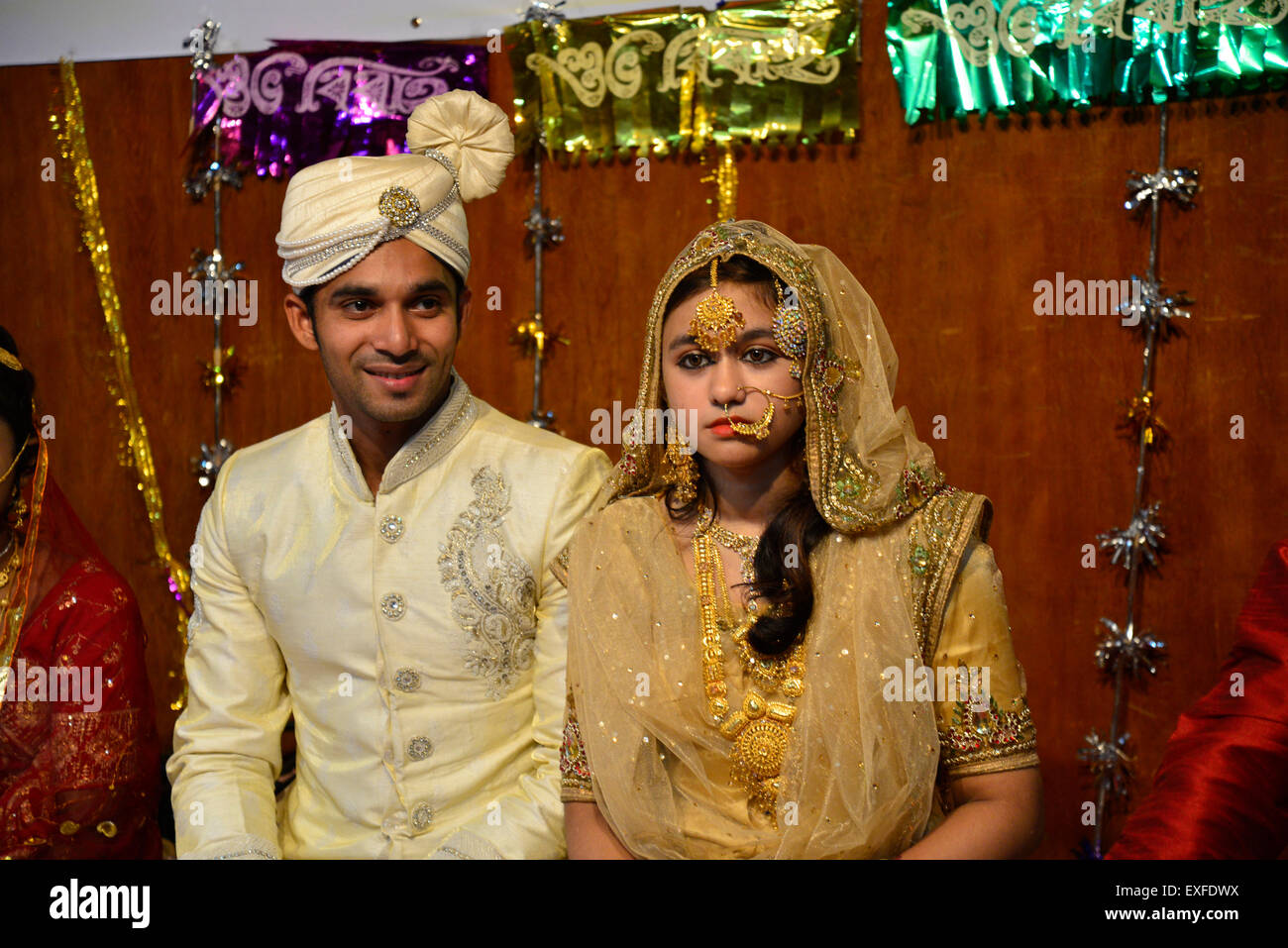 Dhaka, Bangladesh. 13th July, 2015. A Bangladeshi newly married couple participated in the marriage festival at National Museum's auditorium in Dhaka, Bangladesh. On July 13, 2015  A social organization 'Capital Dhaka 400 years celebration Committee' organized a marriage festival at National Museum's auditorium in Dhaka. Newly married couple participated and marriage ceremony's equipments exhibited in the marriage festival. Credit:  Mamunur Rashid/Alamy Live News Stock Photo