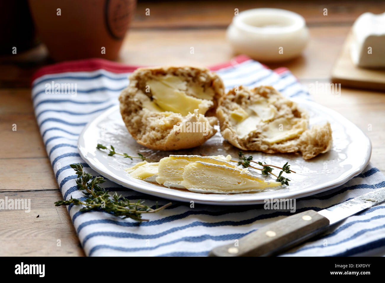 Bread rolls and brie on kitchen table Stock Photo