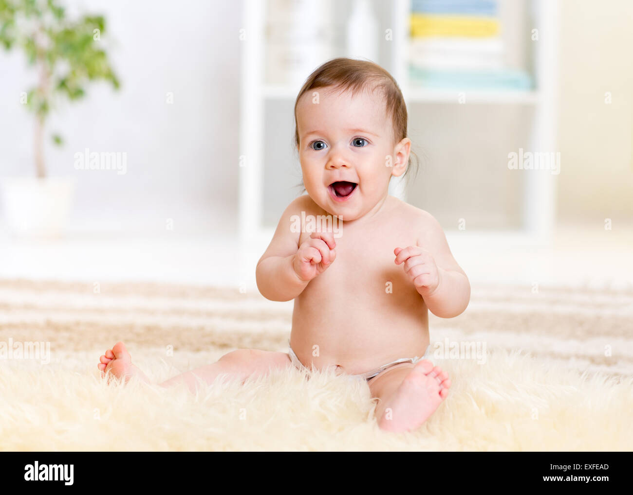 cute baby sitting on fluffy carpet at home Stock Photo