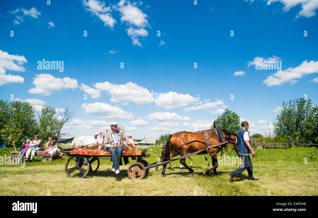 Large family groups riding on horses and carts in field, Rezh, Sverdlovsk Oblast, Russia Stock Photo