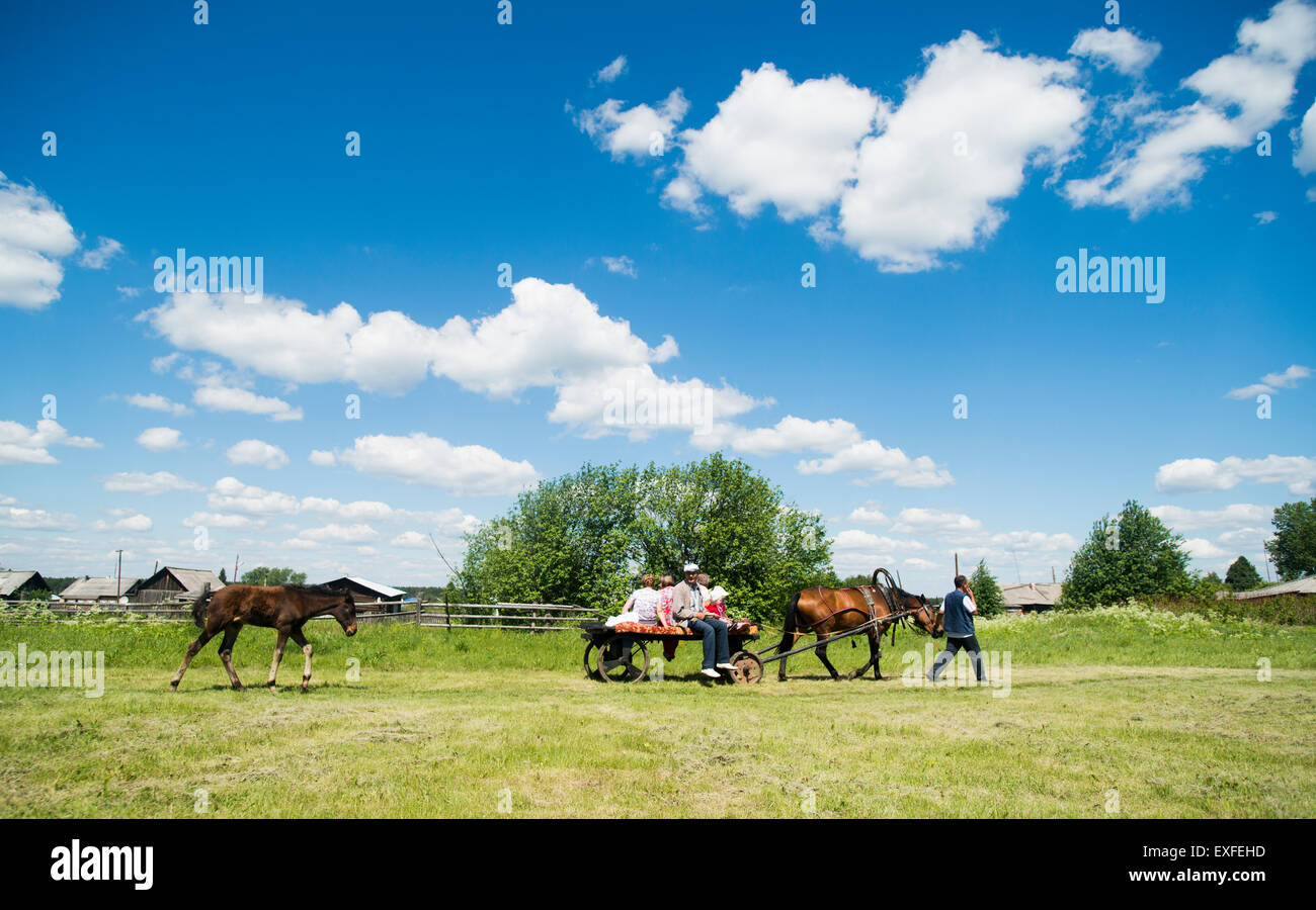 Family riding on horse and cart in field, Rezh, Sverdlovsk Oblast, Russia Stock Photo