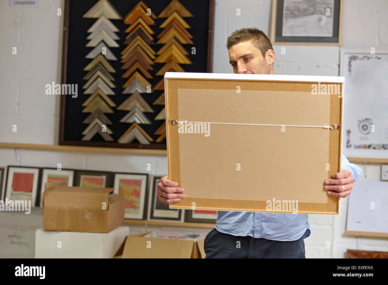 Man inspecting frame in picture framers Stock Photo Alamy