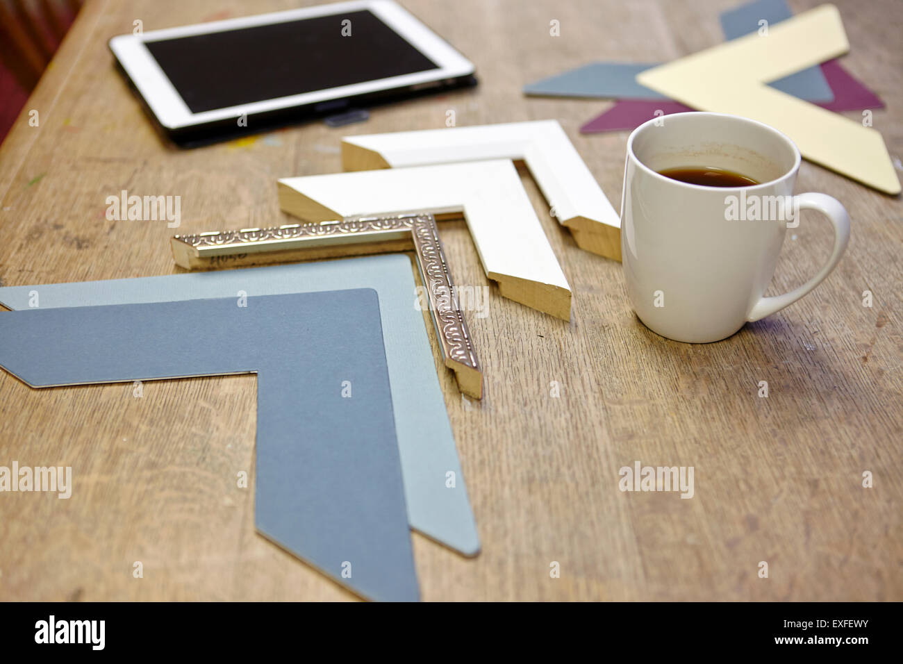 Still life of frames and digital tablet in picture framers workshop Stock Photo