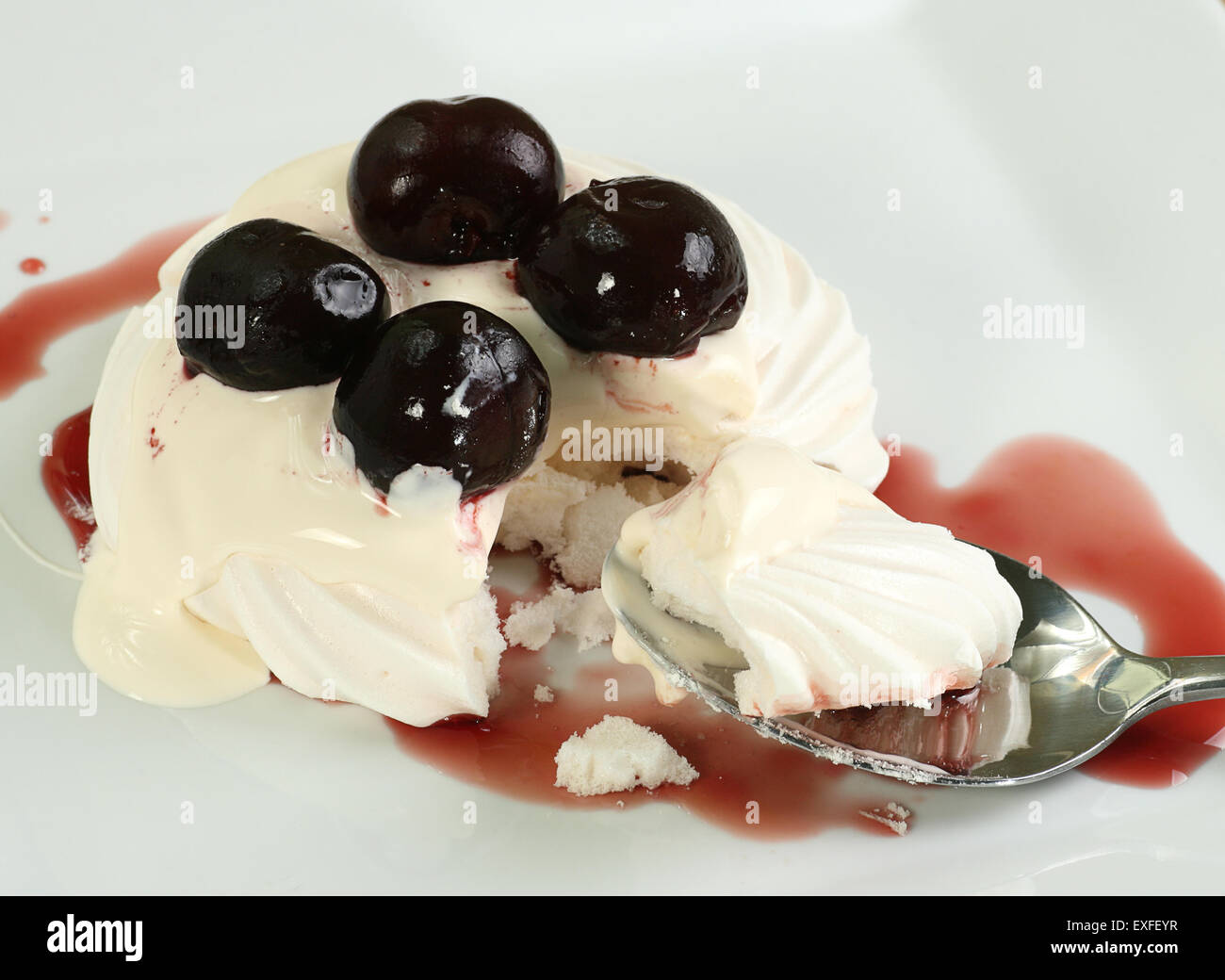 Meringue base with sweet black cherries and whipped cream Stock Photo