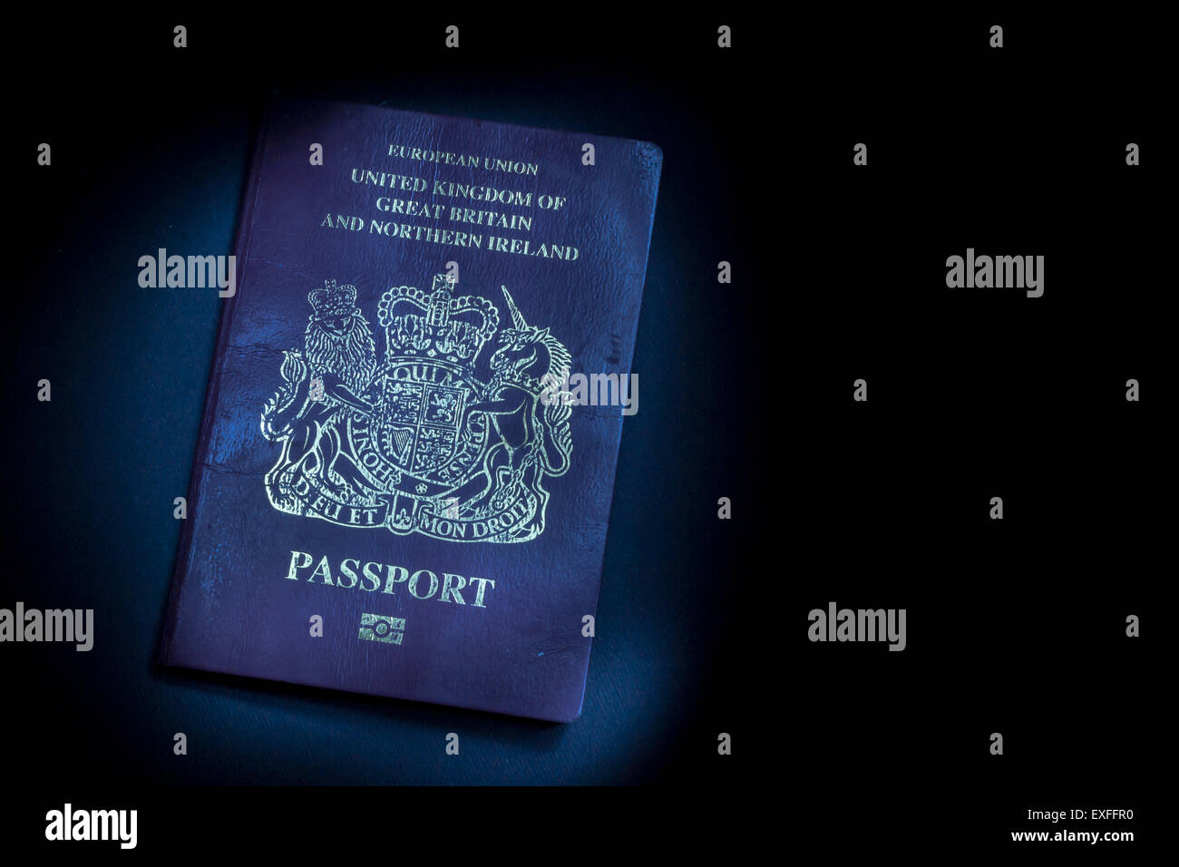 Single well used United Kingdom Passport in a dark shadow background Stock Photo