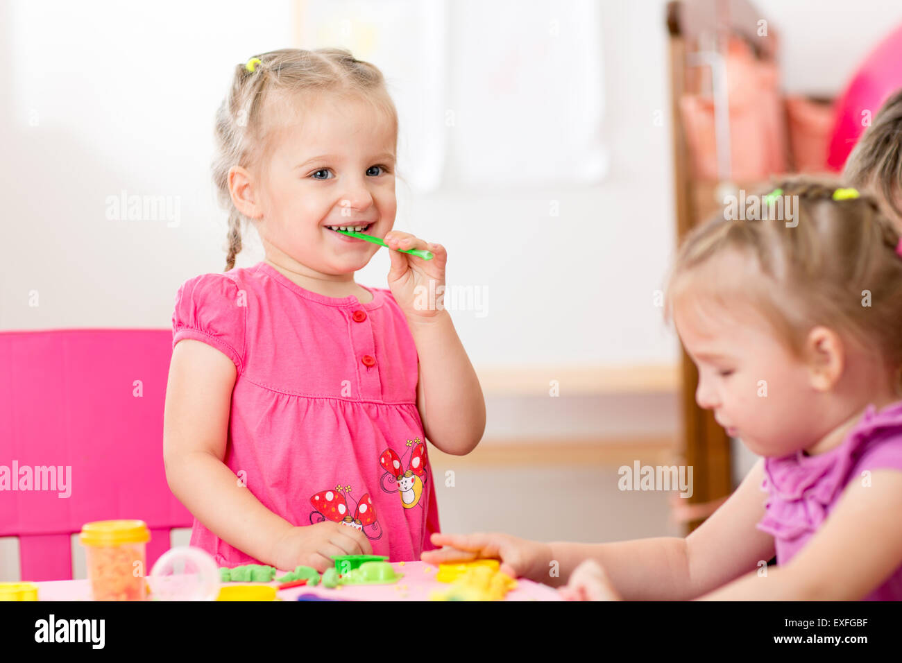 children playing with play clay at home or  playschool Stock Photo