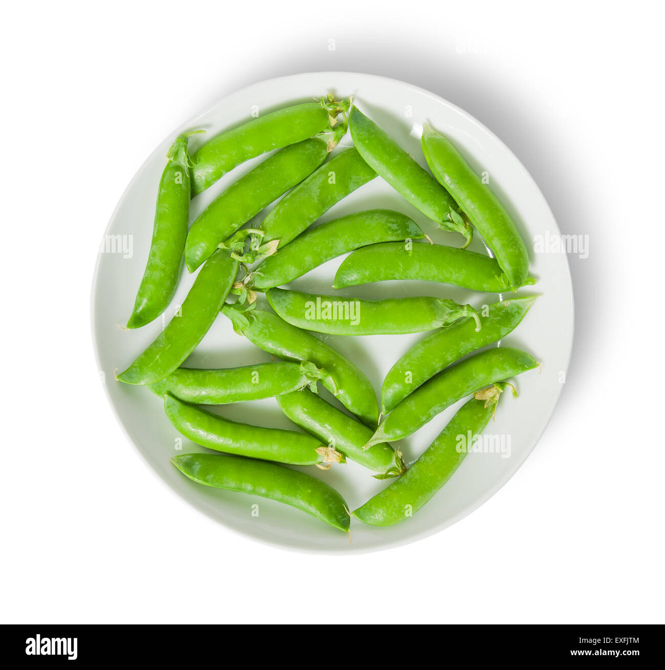 Several pods of peas on a white plate top view isolated on white background Stock Photo