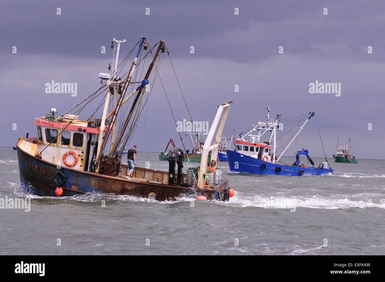 cockle fishing boats "prop-washing" in The Wash, off the Lincolnshire port of Boston, UK. Stock Photo