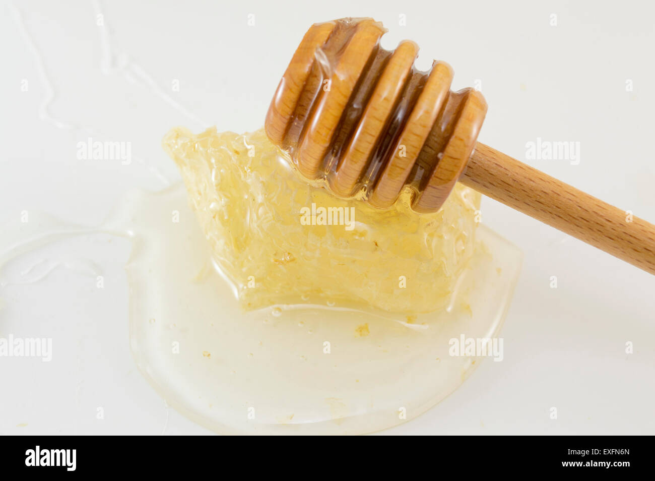 Honeycomb with honey and dipper spoon on white background Stock Photo