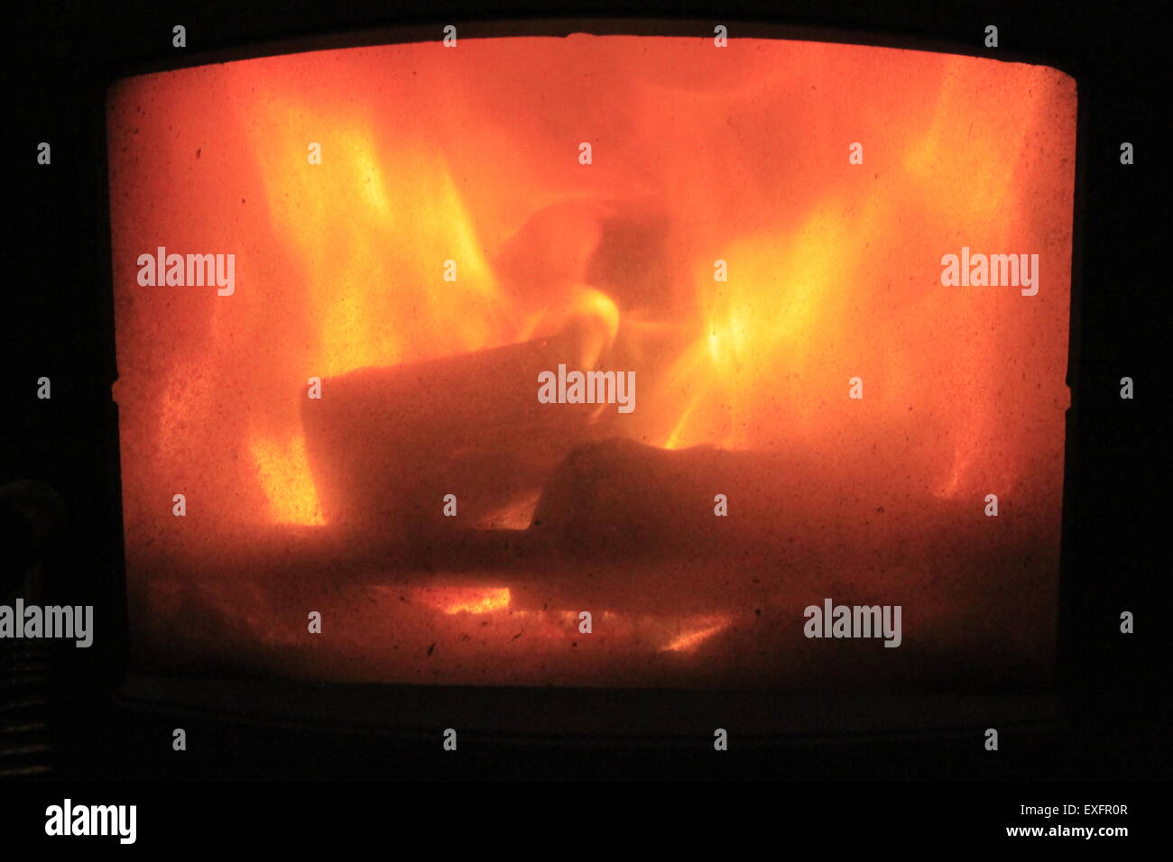 Fireside View Of Logs Burning In Wood Burning Stove Viewed Through