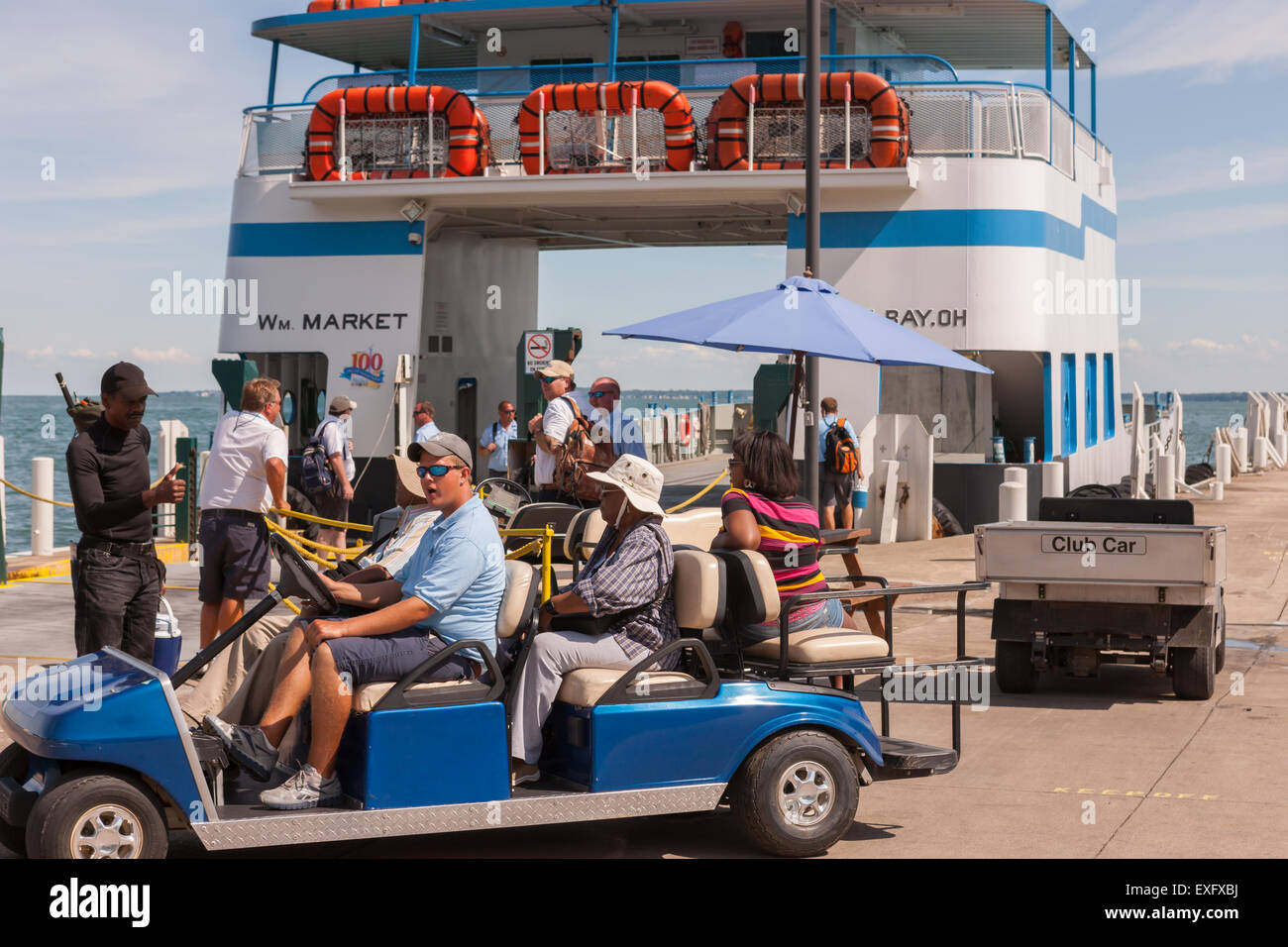 A golf cart prepares to take passengers up the hill from the ferry terminal after arriving in Put-in-Bay, Ohio. Stock Photo
