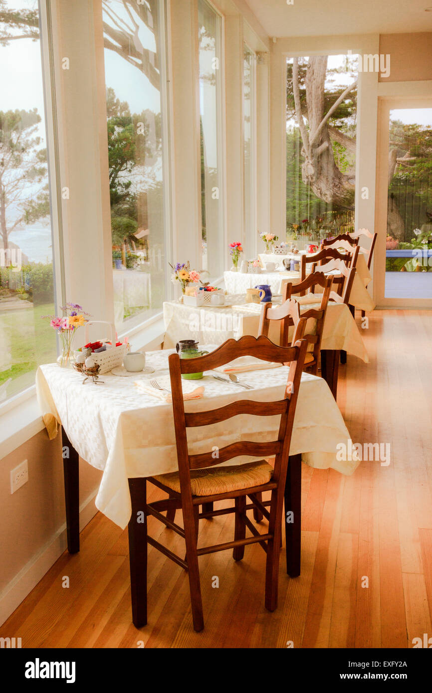 Row of dining tables along big picture windows at a seaside B&B bed and breakfast inn Stock Photo