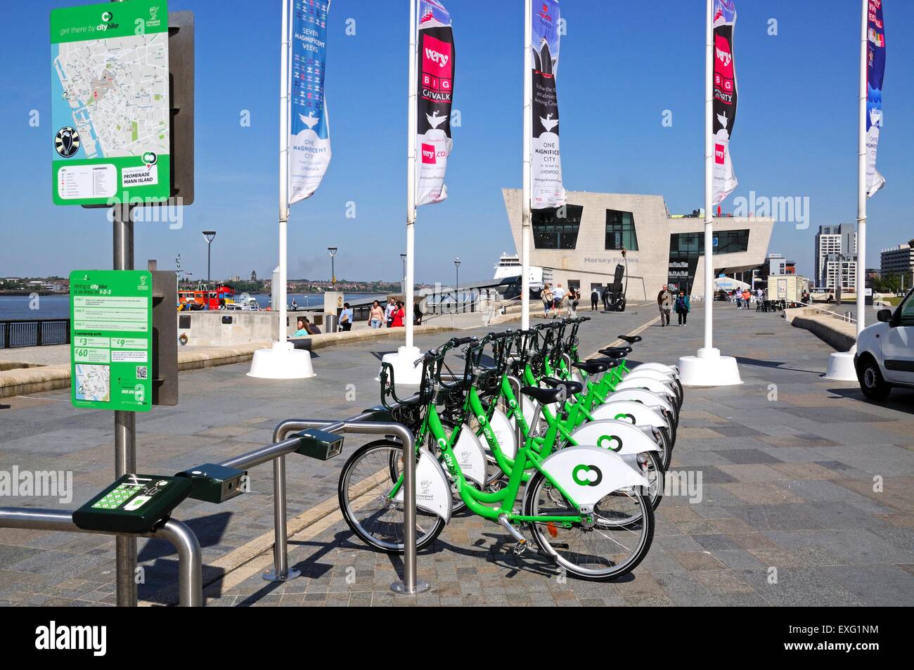 Row of city hire bikes for rent along the waterfront at Pier Head with the Mersey Ferries building to the rear, Liverpool, UK. Stock Photo