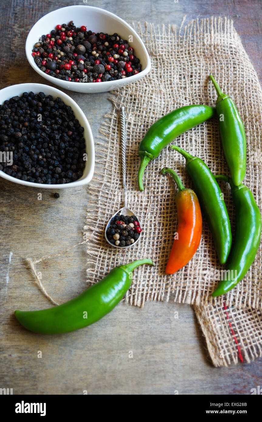 closeup green chilli peppers and different types of peppercorns Stock