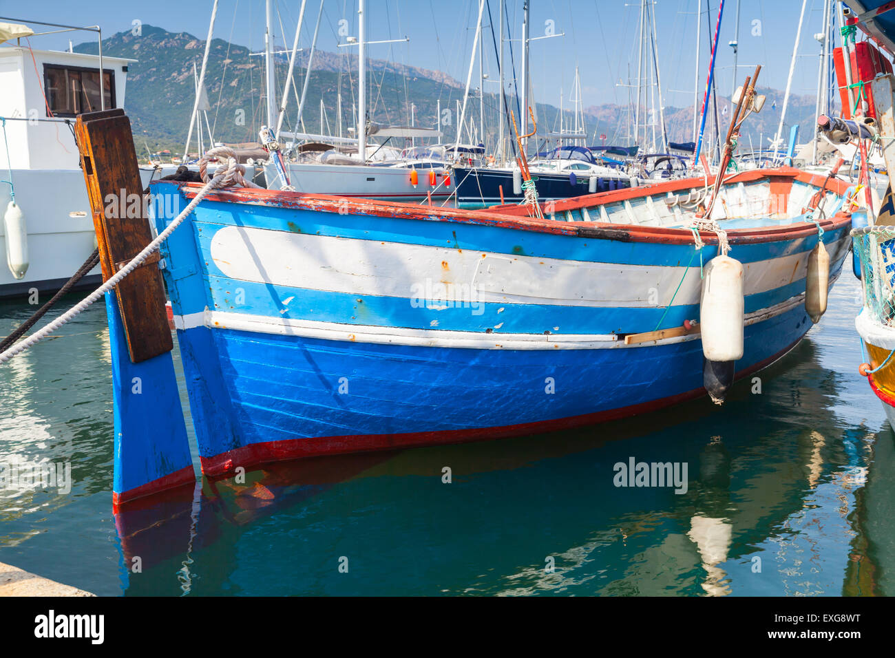 Small blue and white wooden fishing boat moored in Propriano town, Corsica, France Stock Photo
