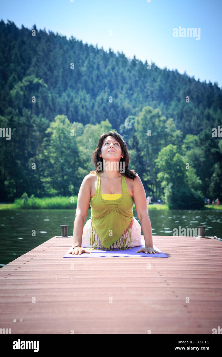 woman making yoga exercise at a lake Stock Photo - Alamy