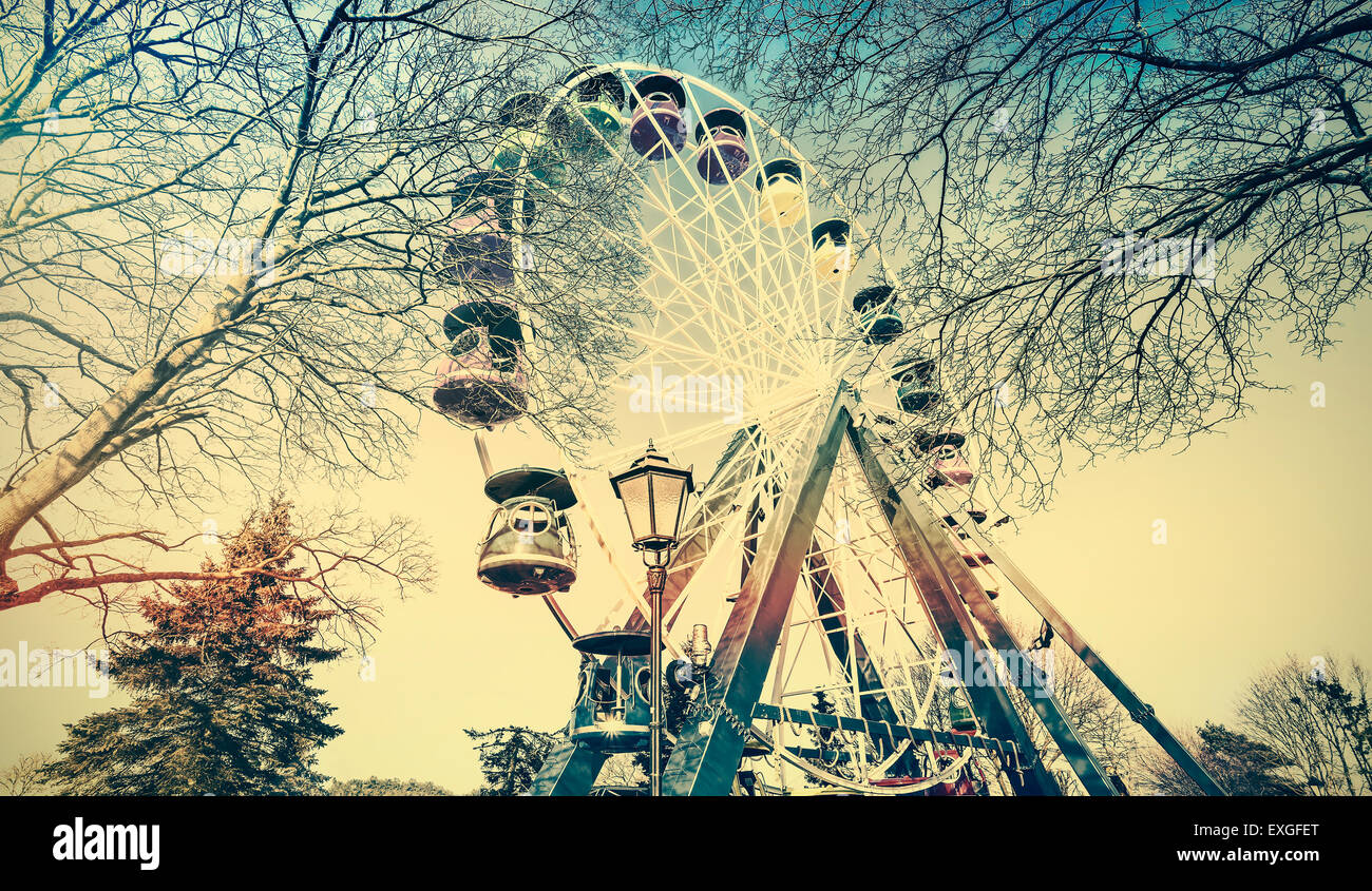 Retro old film faded picture of ferris wheel in a park. Stock Photo