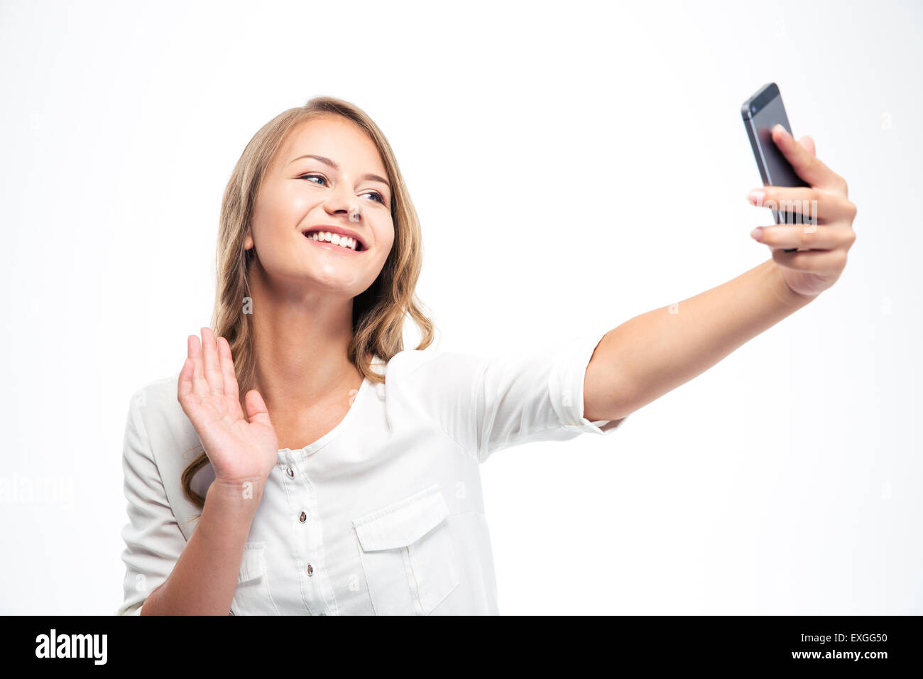 Smiling young girl making selfie photo while waving palm isolated on a ...