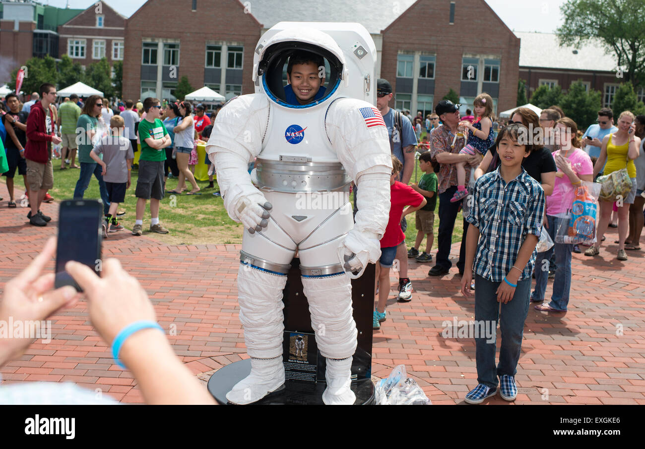 Visitors line up to make their photo inside a space suit exhibit during the TouchTomorrow Festival, held in conjunction with the 2015 Sample Return Robot Challenge, Saturday, June 13, 2015 at the Worcester Polytechnic Institute (WPI) in Worcester, Mass.  Sixteen teams competed for a $1.5 million NASA prize purse. Teams will be required to demonstrate autonomous robots that can locate and collect samples from a wide and varied terrain, operating without human control. The objective of this NASA-WPI Centennial Challenge is to encourage innovations in autonomous navigation and robotics technologi Stock Photo